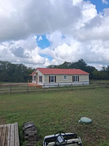 a view of a lake with a big yard and large trees