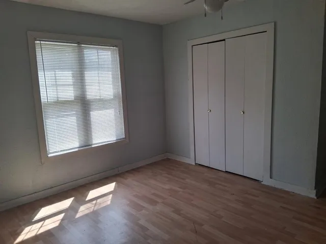 an empty room with wooden floor and windows