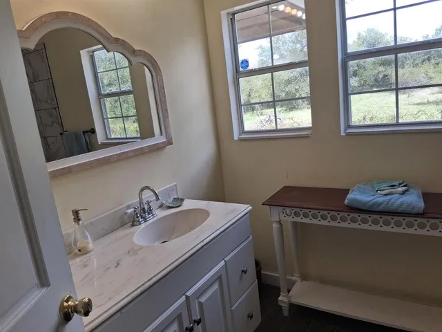 a bathroom with a sink a mirror and a window