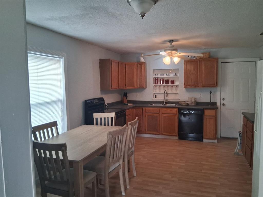 1584 Kelly Road, Unit A Aledo, TX 76008 - Photo 5 of 15 a kitchen with a table chairs a sink dishwasher refrigerator and cabinets