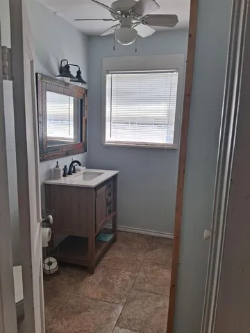 a bathroom with a sink a mirror and a window
