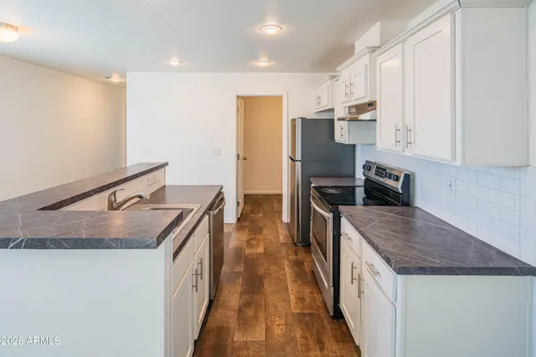 a kitchen with stainless steel appliances granite countertop a sink stove and refrigerator