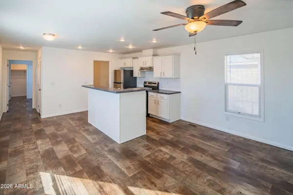 a view of kitchen with kitchen island stainless steel appliances refrigerator stove microwave and cabinets