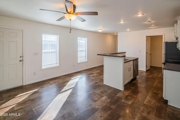 a kitchen with kitchen island granite countertop appliances cabinets and a wooden floor