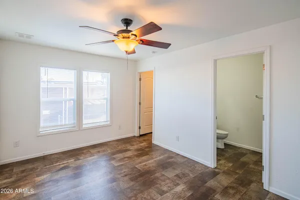 an empty room with window and ceiling fan