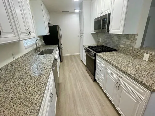 a kitchen with a sink stove and microwave