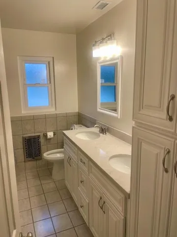 a bathroom with a granite countertop sink mirror and toilet