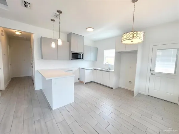 a large room with a lot of cabinets and wooden floor
