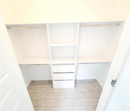 a view of walk in closet with empty racks