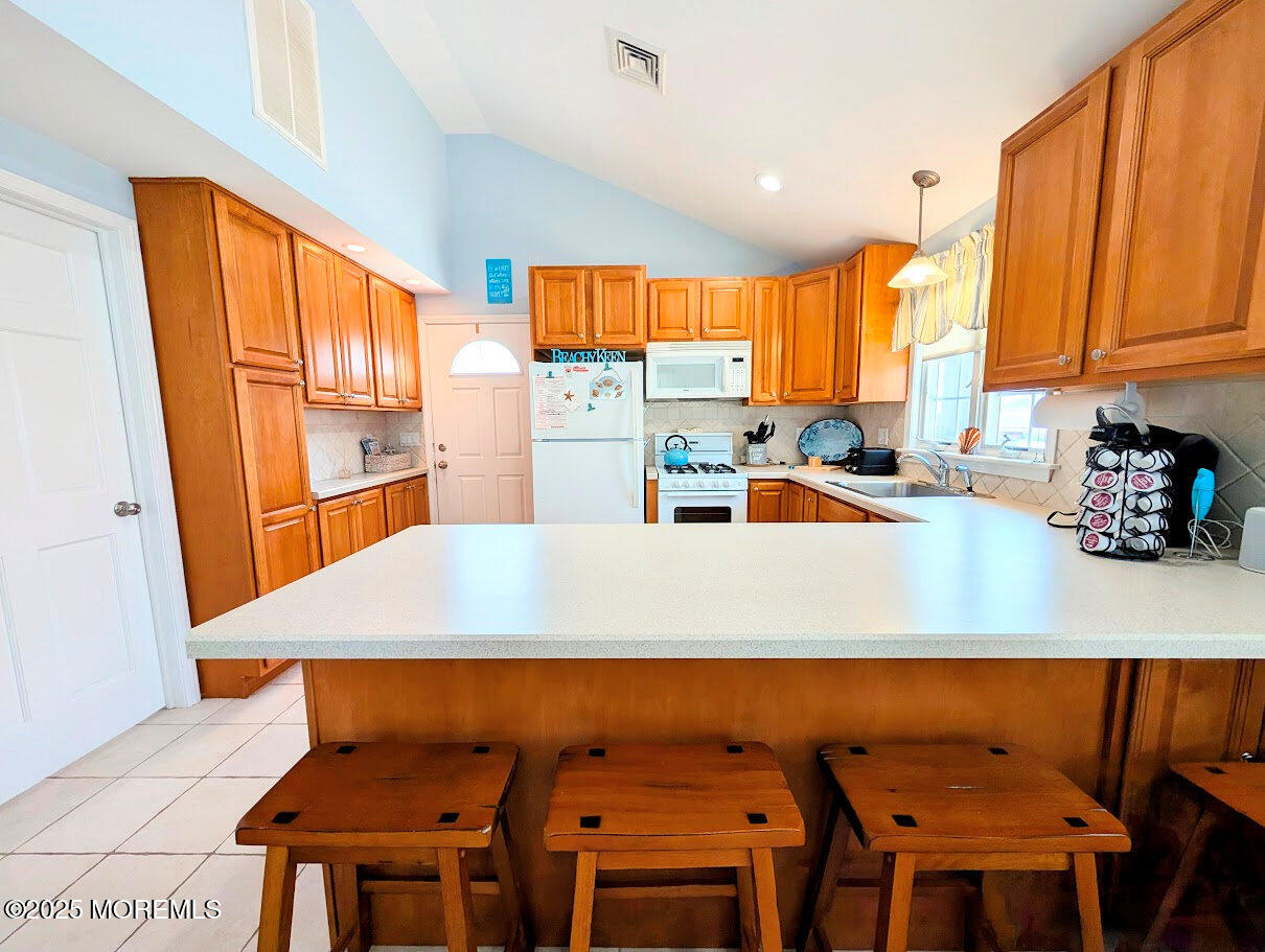 31 East Cormorant Way Lavallette, NJ 08735 - Photo 11 of 22 a kitchen with a table chairs and a refrigerator