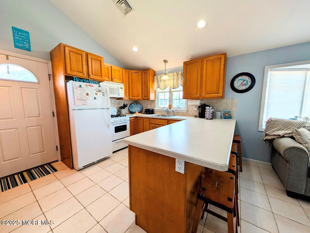 31 East Cormorant Way Lavallette, NJ 08735 - Photo 10 of 22 a kitchen with stainless steel appliances a stove a refrigerator a sink a dining table and chairs