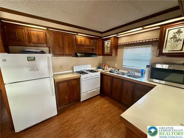 a kitchen with stainless steel appliances granite countertop a stove a sink dishwasher and a refrigerator