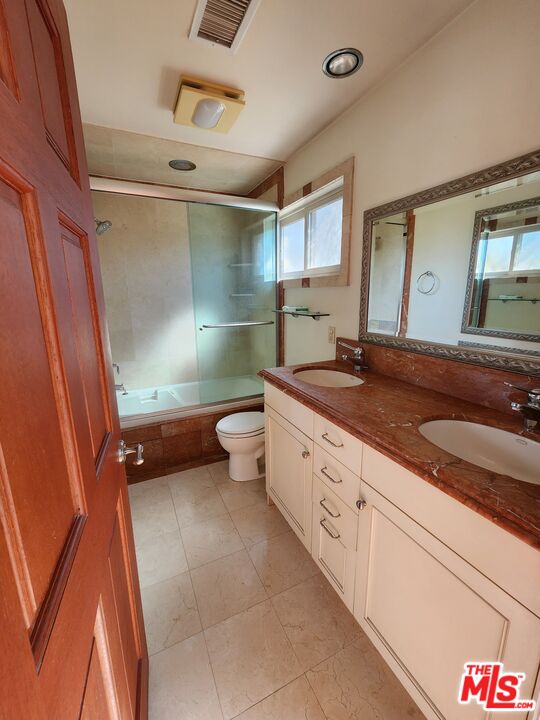 Almayo Avenue Los Angeles, CA 90064 - Photo 19 of 35 a bathroom with a granite countertop sink a toilet and a mirror