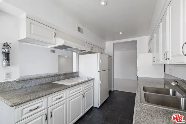 a kitchen with granite countertop a sink stainless steel appliances and cabinets