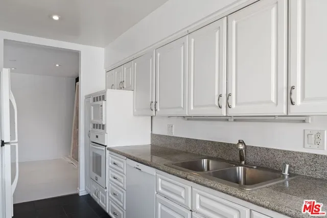 a kitchen with stainless steel appliances white cabinets and a sink