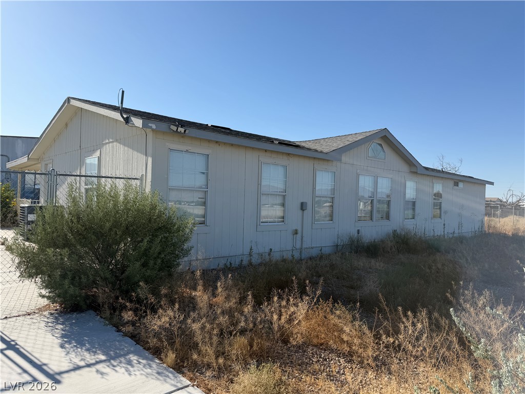6041 Hafen Ranch Road Pahrump, NV 89061 - Photo 2 of 12 A modest home with vinyl siding and ample windows sits on a clear, sunny day.