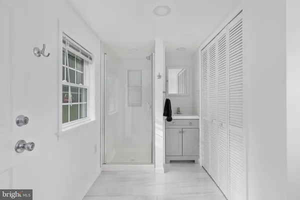 a view of kitchen with refrigerator and white cabinets