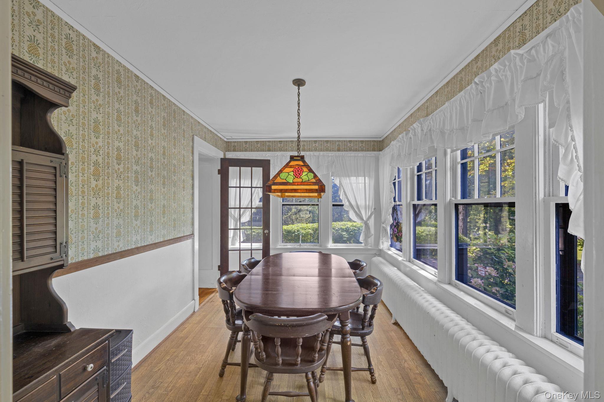 470 Little Britain Road Newburgh, NY 12550 - Photo 24 of 45 Dining space with wood finished floors, wallpapered walls, ornamental molding, radiator heating unit, and wainscoting