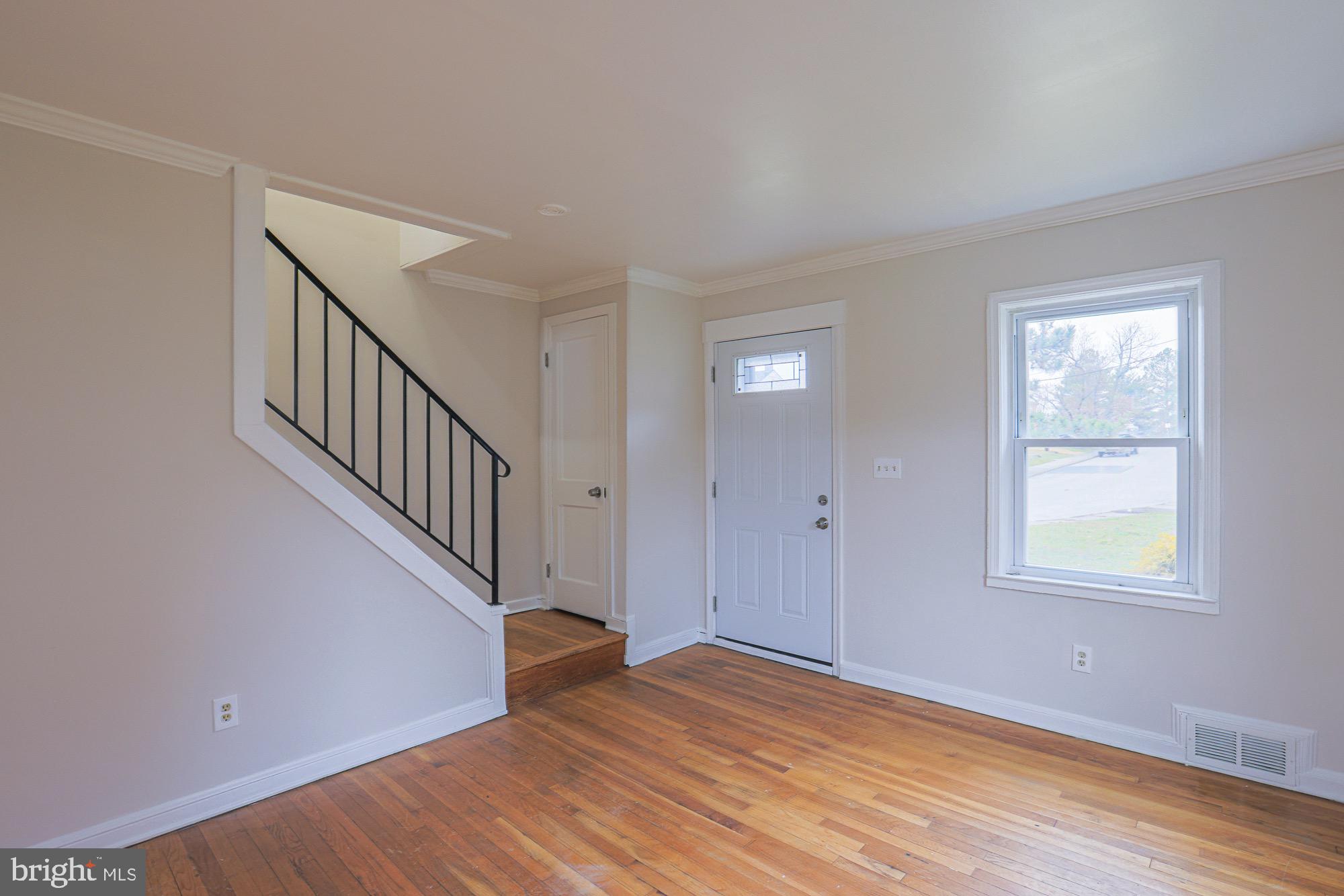 1022 Cameron Road Baltimore, MD 21212 - Photo 5 of 21 a view of an empty room with wooden floor and a window