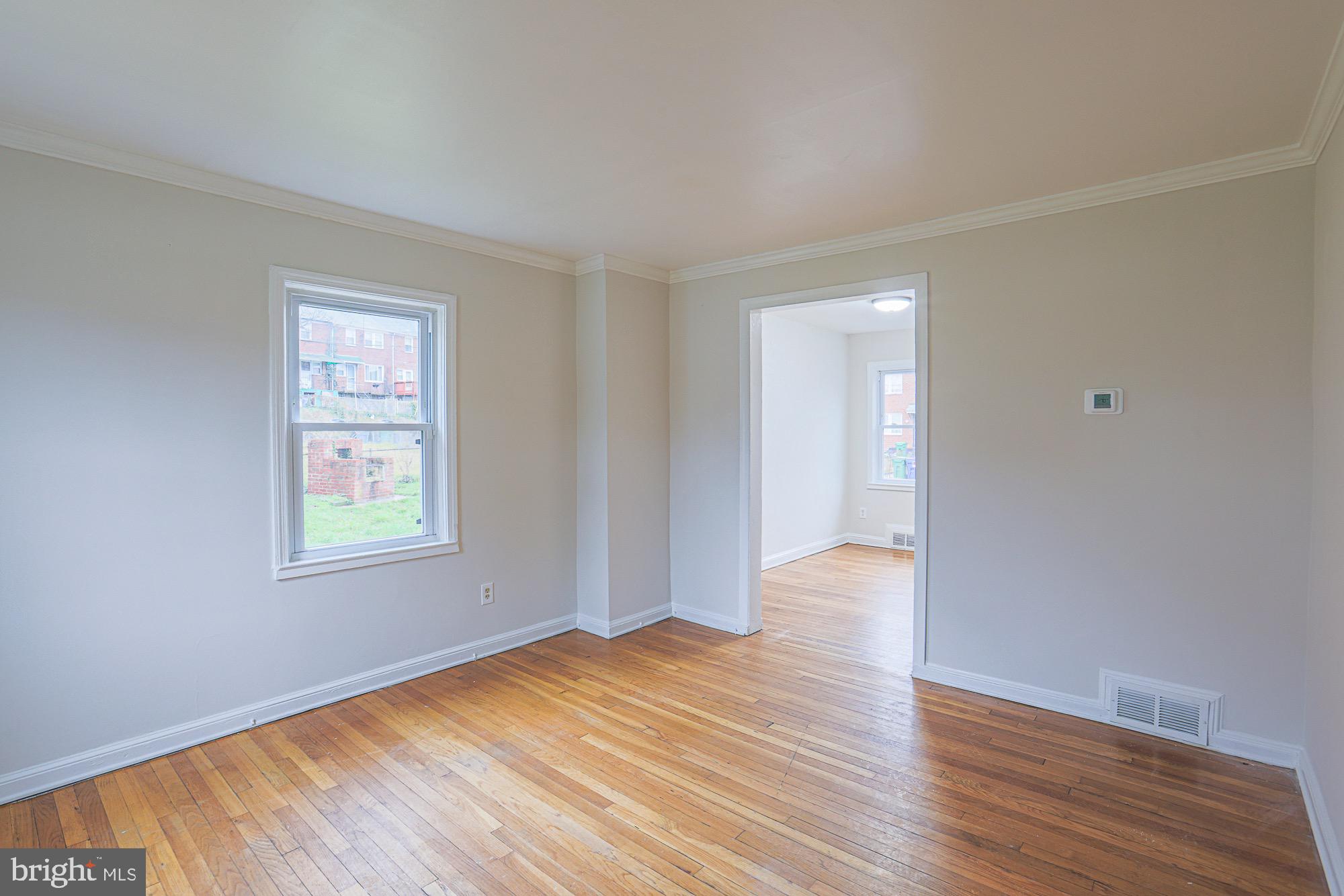 1022 Cameron Road Baltimore, MD 21212 - Photo 6 of 21 a view of an empty room with wooden floor and a window
