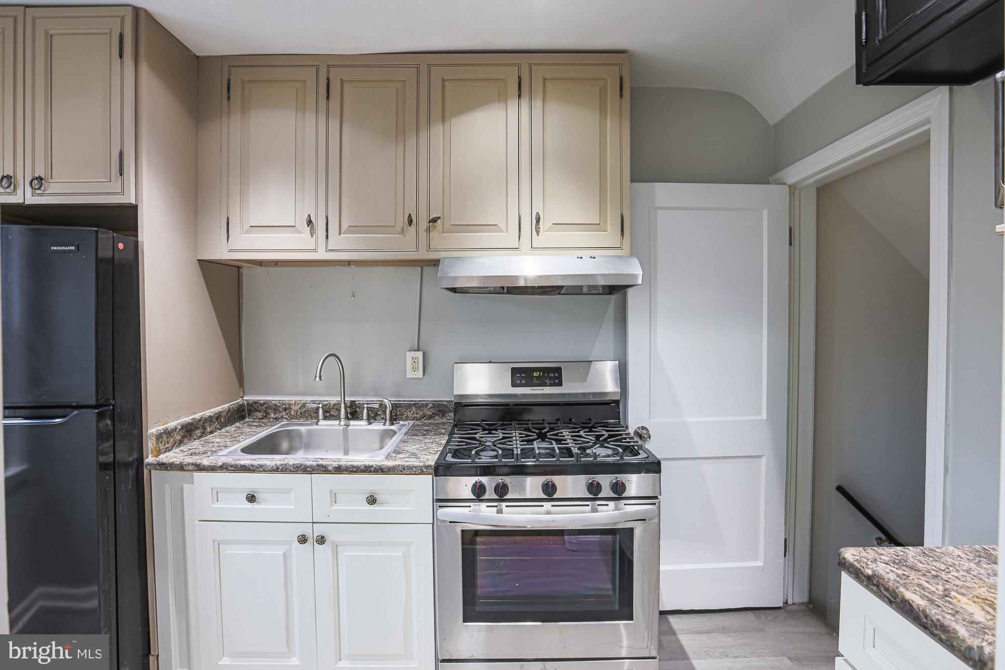 1022 Cameron Road Baltimore, MD 21212 - Photo 8 of 21 a kitchen with granite countertop a stove and a white cabinets
