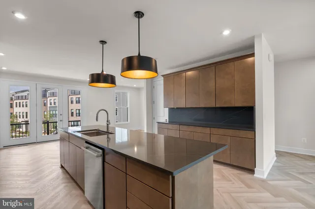 a kitchen with stainless steel appliances granite countertop a sink a oven and a wooden floors