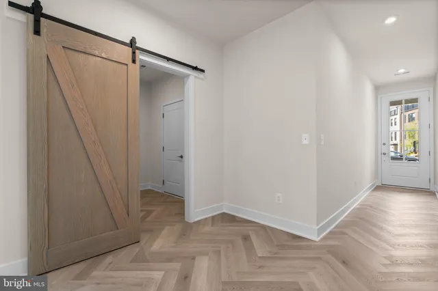 an empty room with wooden floor and entrance