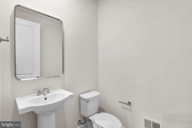 a bathroom with a sink a mirror and a toilet
