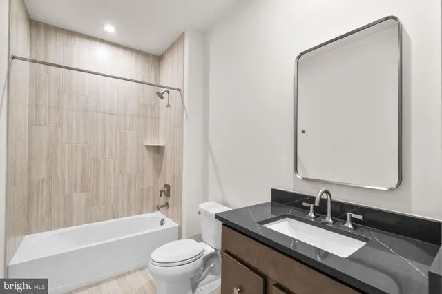 a bathroom with a granite countertop sink toilet and shower