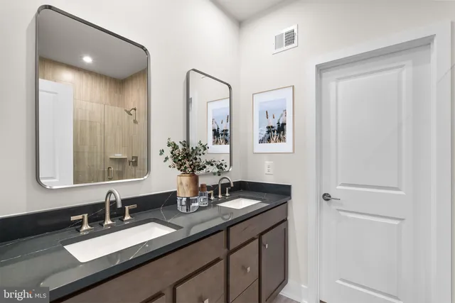 a bathroom with double vanity sinks and a mirror