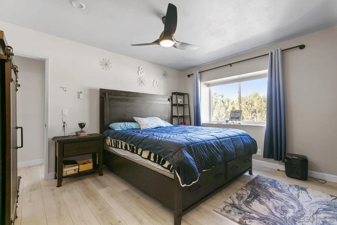 6381 Rancho Mission Road, Unit 6 San Diego, CA 92108 - Photo 19 of 30 a bed sitting in a bedroom next to a window