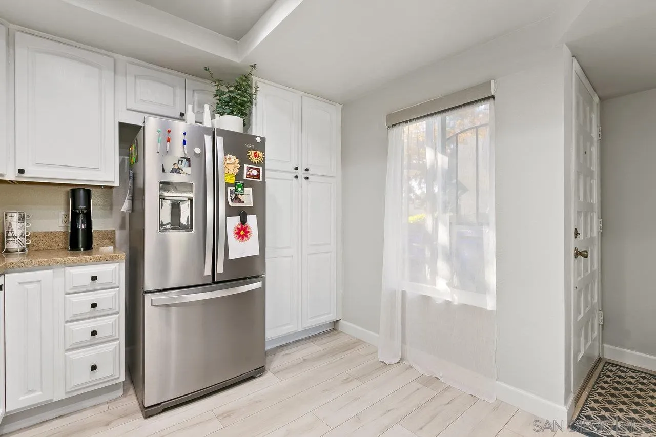 6381 Rancho Mission Road, Unit 6 San Diego, CA 92108 - Photo 10 of 30 a kitchen with stainless steel appliances granite countertop a refrigerator and a window