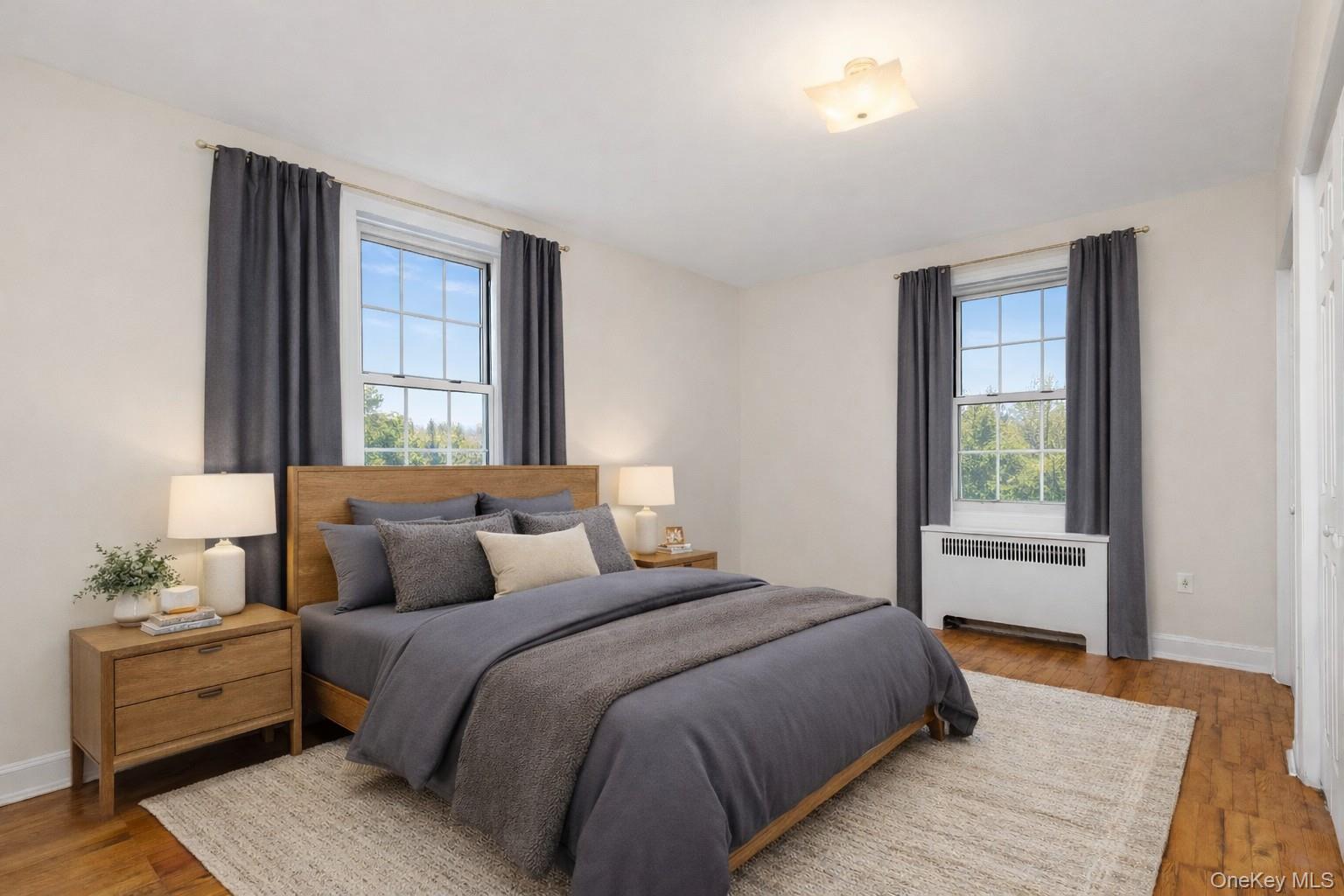 60 Pinewood Road, Unit 1B Hartsdale, NY 10530 - Photo 12 of 27 Virtually staged bedroom featuring 4 closets, hardwood floors, and multiple windows.