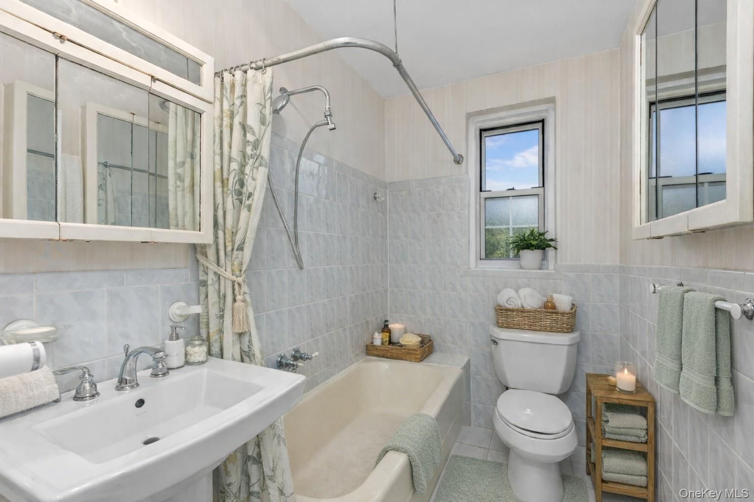 60 Pinewood Road, Unit 1B Hartsdale, NY 10530 - Photo 15 of 27 Virtually staged bathroom featuring tile walls, shower / bath combination with shower curtain, and tile patterned flooring.
