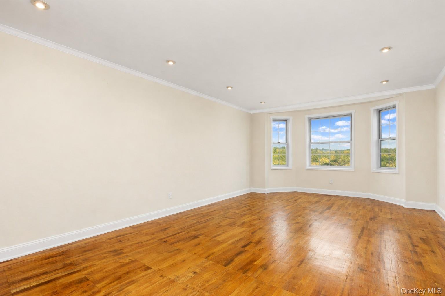 60 Pinewood Road, Unit 1B Hartsdale, NY 10530 - Photo 4 of 27 Large living room featuring hardwood floors, crown molding and recessed lighting.