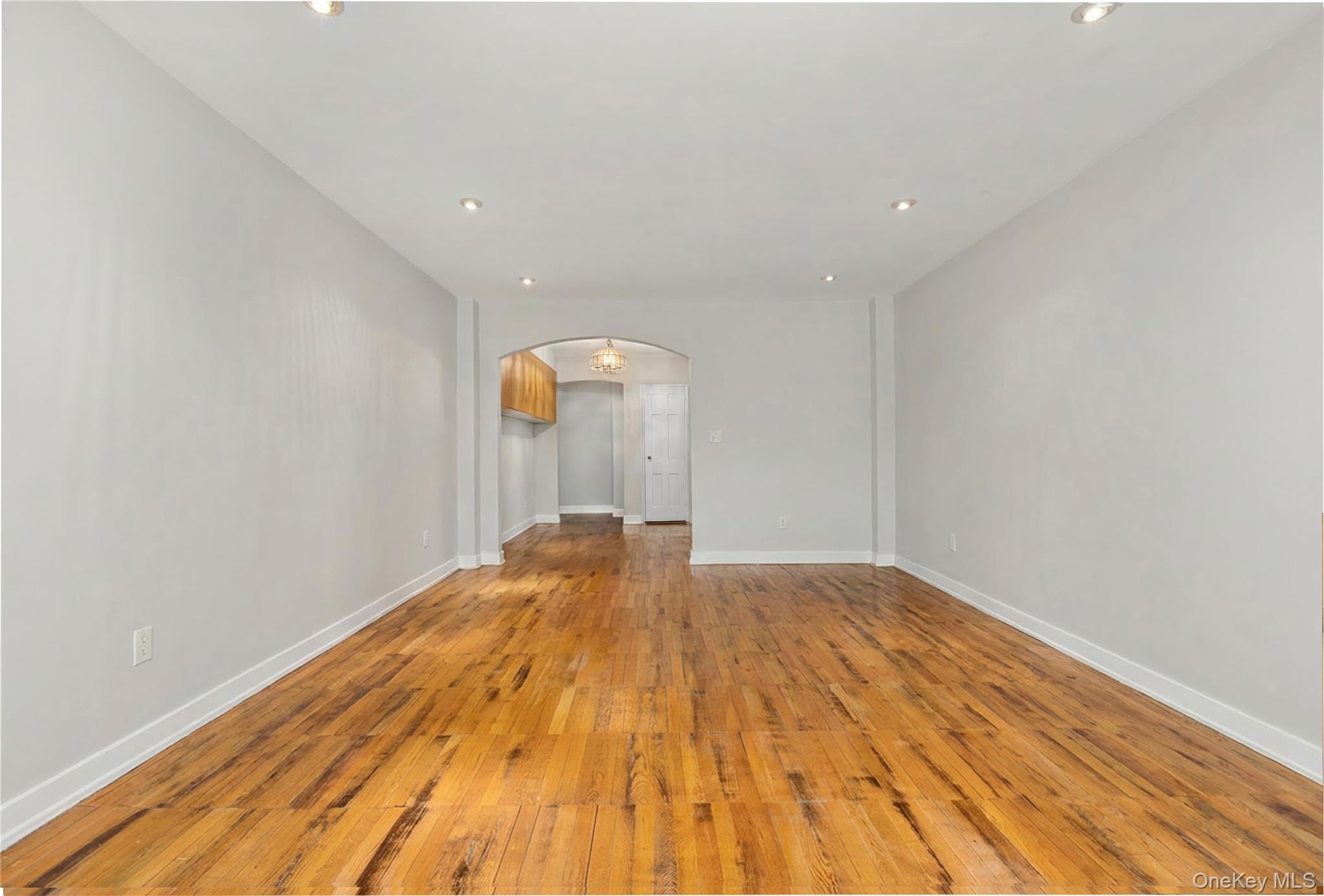 60 Pinewood Road, Unit 1B Hartsdale, NY 10530 - Photo 6 of 27 Large living room featuring arched walkways, hardwood floors, and recessed lighting.