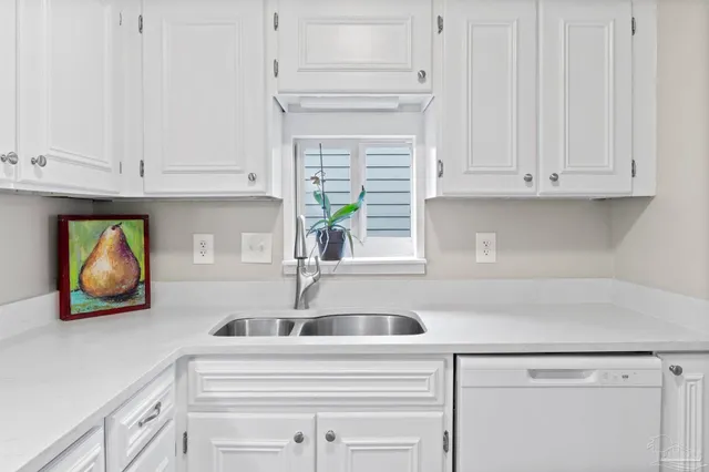 a kitchen with white cabinets and a sink