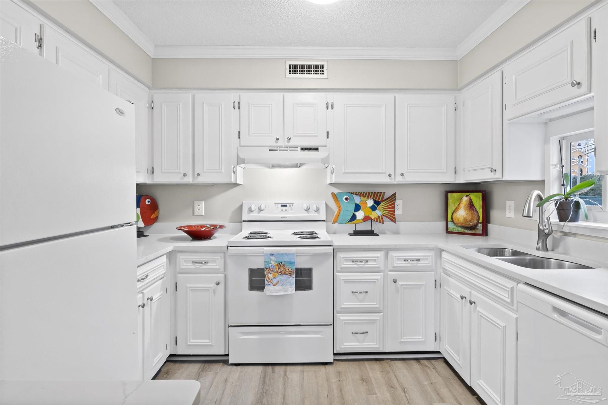 16470 Perdido Key Drive, Unit C24 Perdido Key, FL 32507 - Photo 13 of 48 a kitchen with white cabinets and white appliances