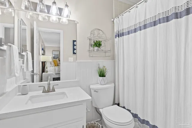 a bathroom with a sink a toilet and shower curtain