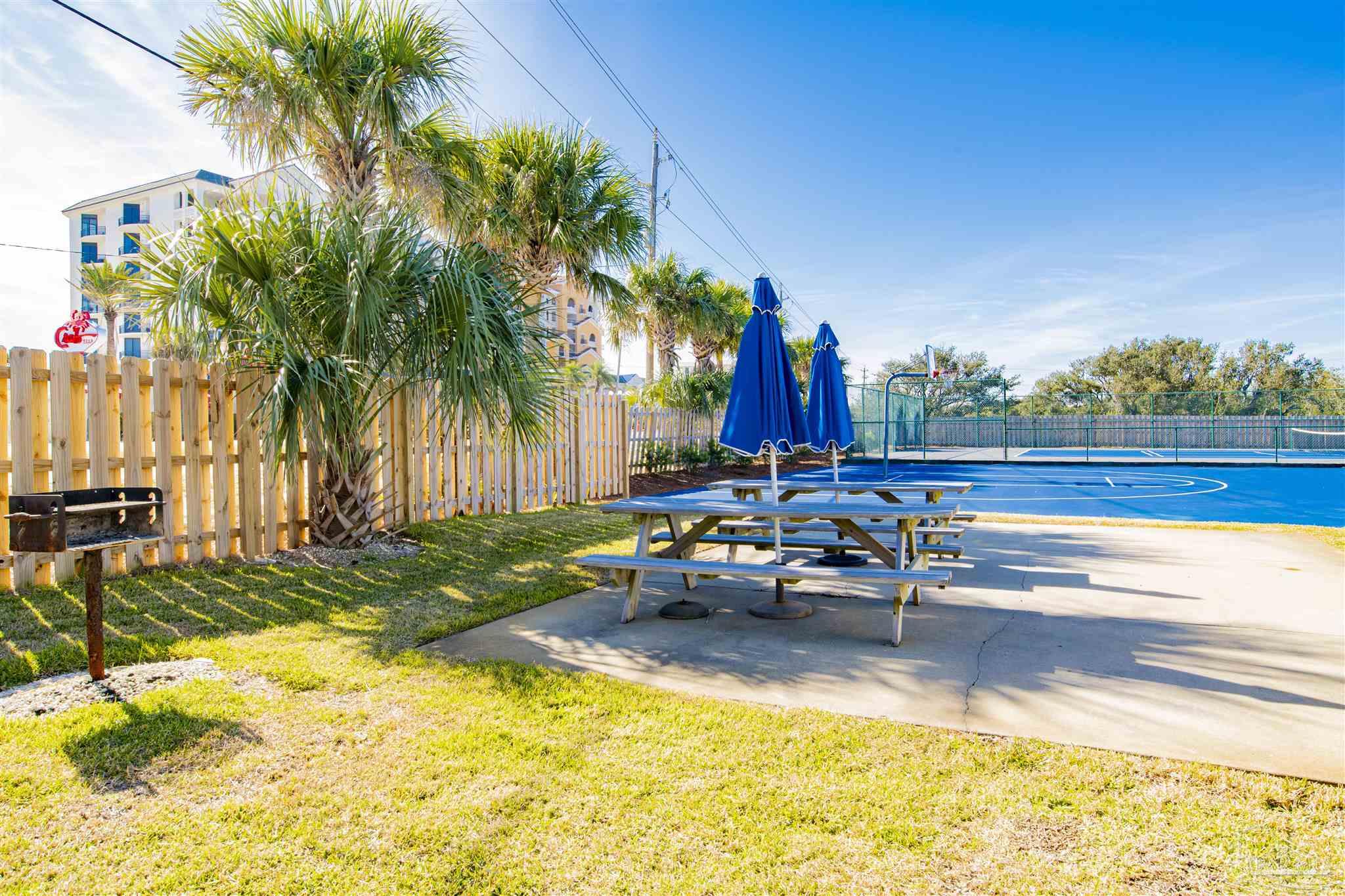 16470 Perdido Key Drive, Unit C24 Perdido Key, FL 32507 - Photo 31 of 48 a view of a swimming pool with a lounge chair and palm trees