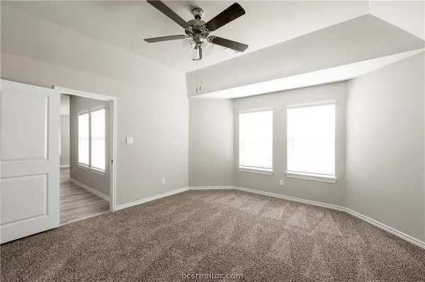an empty room with fan and windows