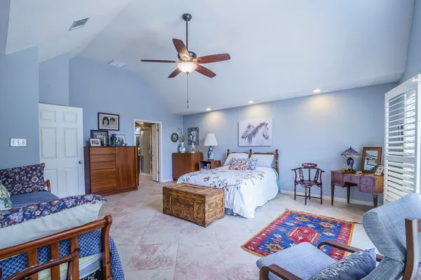 a spacious bedroom with a bed and a chandelier