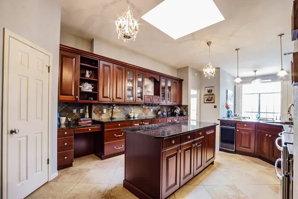 a kitchen with stainless steel appliances granite countertop a stove a sink dishwasher and cabinets with wooden floor
