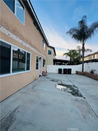 a view of a house with a yard and potted plants