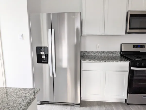 a kitchen with stainless steel appliances granite countertop a refrigerator and a stove
