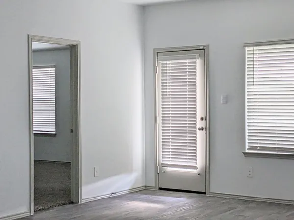 a view of an empty room with a window and a bathroom