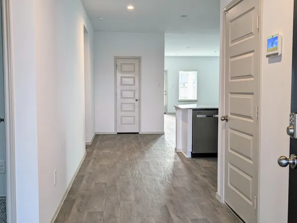 a view of a kitchen with white cabinets and wooden floor