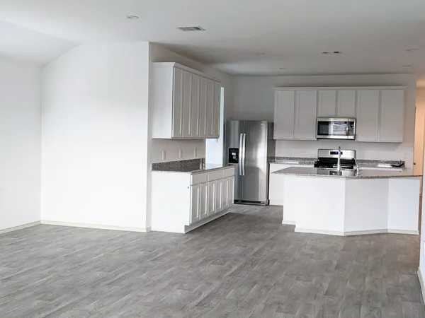 a kitchen with stainless steel appliances white cabinets and a refrigerator