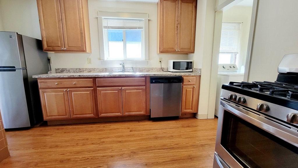149 Powder House Boulevard, Unit 149 Somerville, MA 02144 - Photo 1 of 11 a kitchen with stainless steel appliances granite countertop a stove a sink and a refrigerator