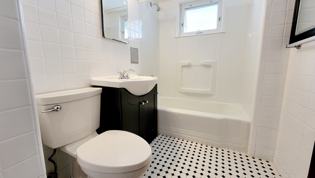 149 Powder House Boulevard, Unit 149 Somerville, MA 02144 - Photo 5 of 11 a bathroom with a sink a toilet and shower